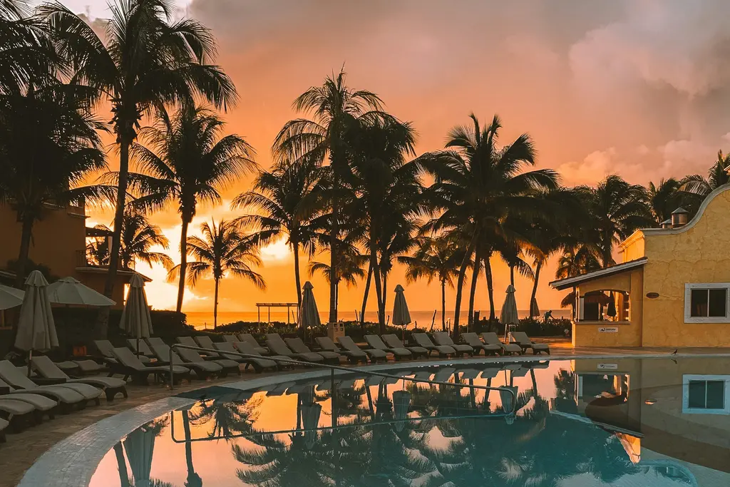 Pool with palm trees at sunset in Cancún