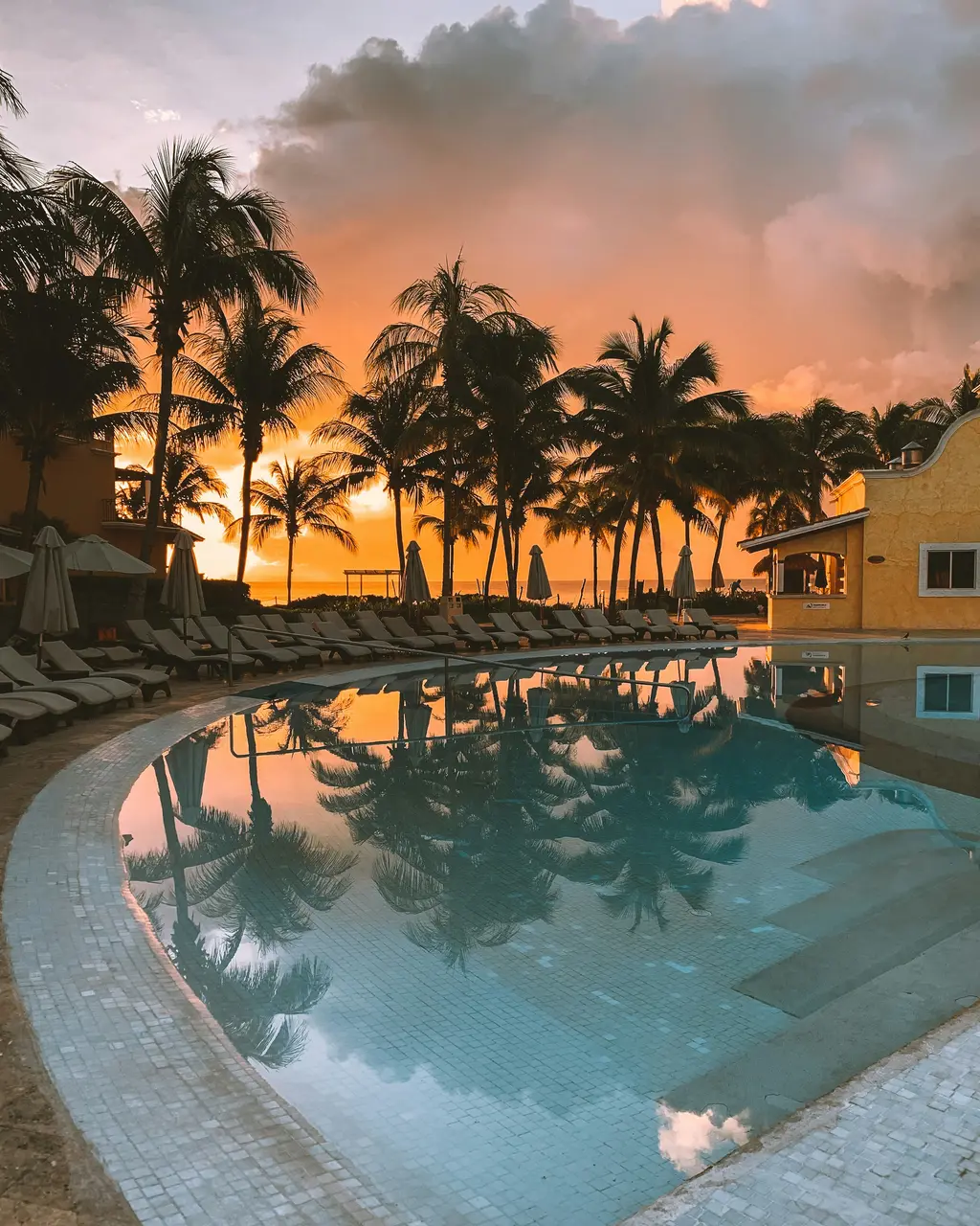 Pool with palm trees at sunset in Cancún