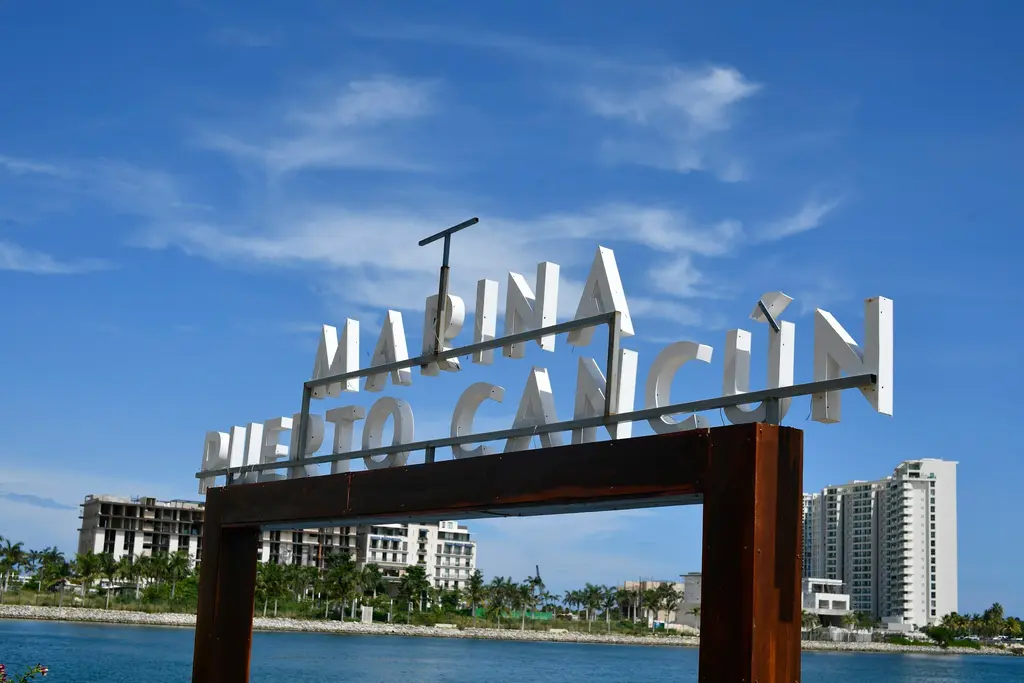 Marina Puerto Cancún sign with buildings behind