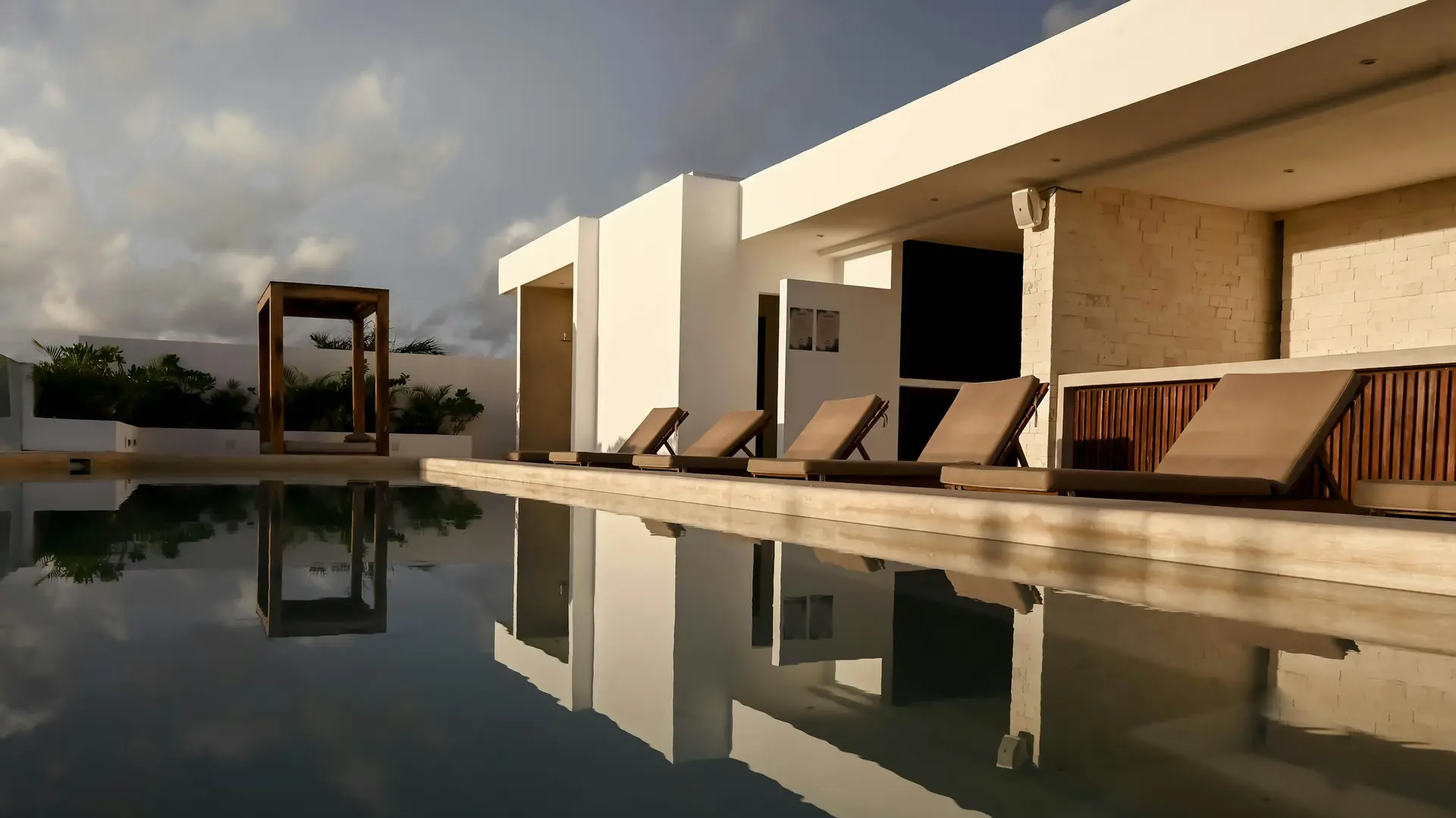 Loungers beside a long pool in Tulum