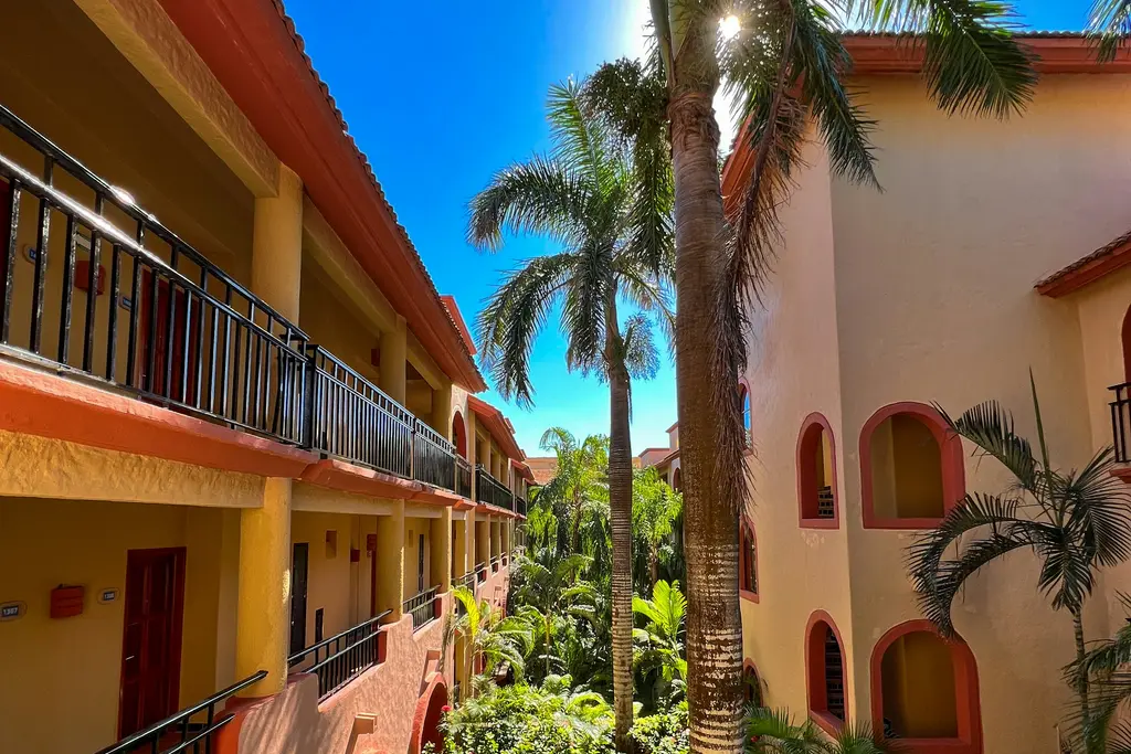Balconied walkway with palm trees in a Mexican-style building in Playa del Carmen