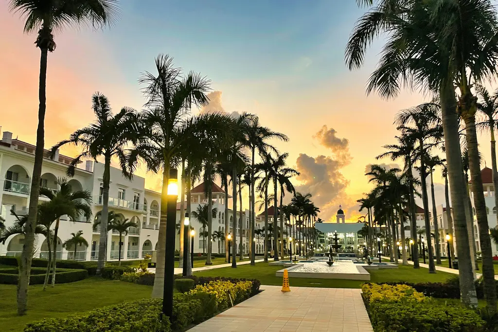 Palm-lined walkway at sunset in Playa del Carmen