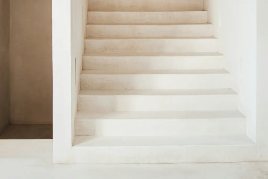 Minimalist light-finish staircase with natural light in Tulum