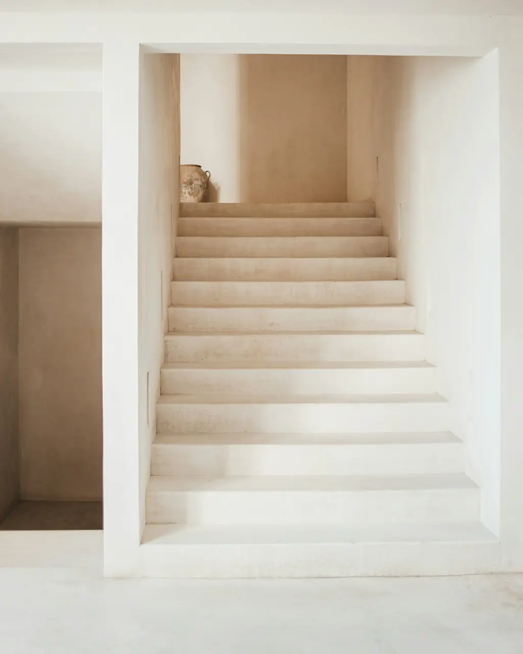 Minimalist light-finish staircase with natural light in Tulum