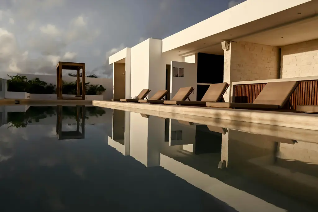 Long pool reflecting a modern building in Tulum