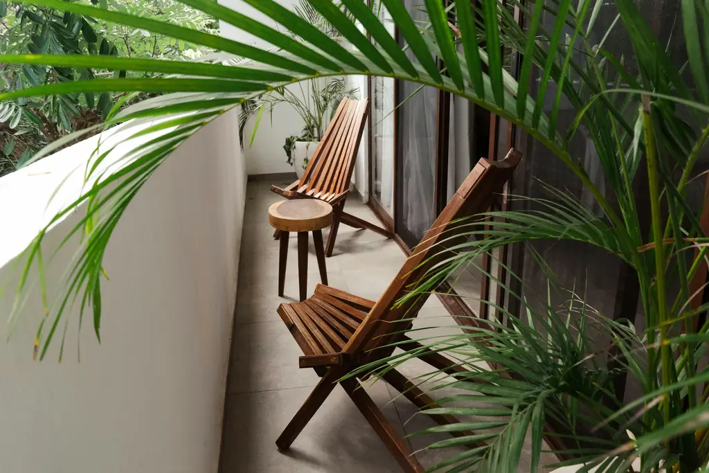 Balcony with wooden chairs and palms in Tulum